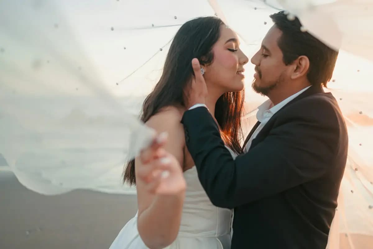 Couple together beneath a sheer veil